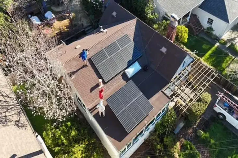 Brown roof before replacement, showing solar panels during removal by roofing professionals