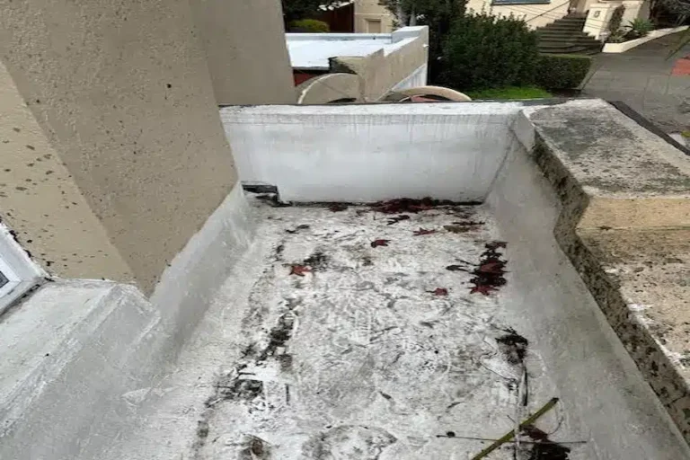 Worn and weather-stained flat roof walkway before professional resurfacing