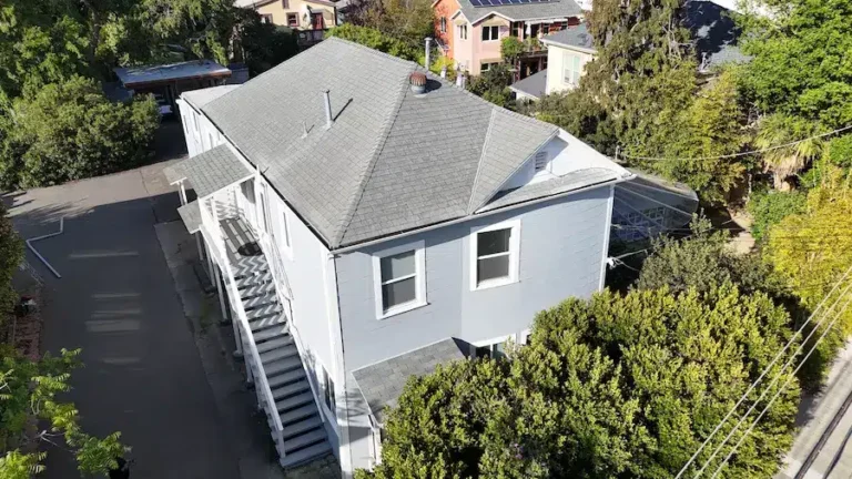 Faded, aging shingle roof on a multi-unit home before replacement