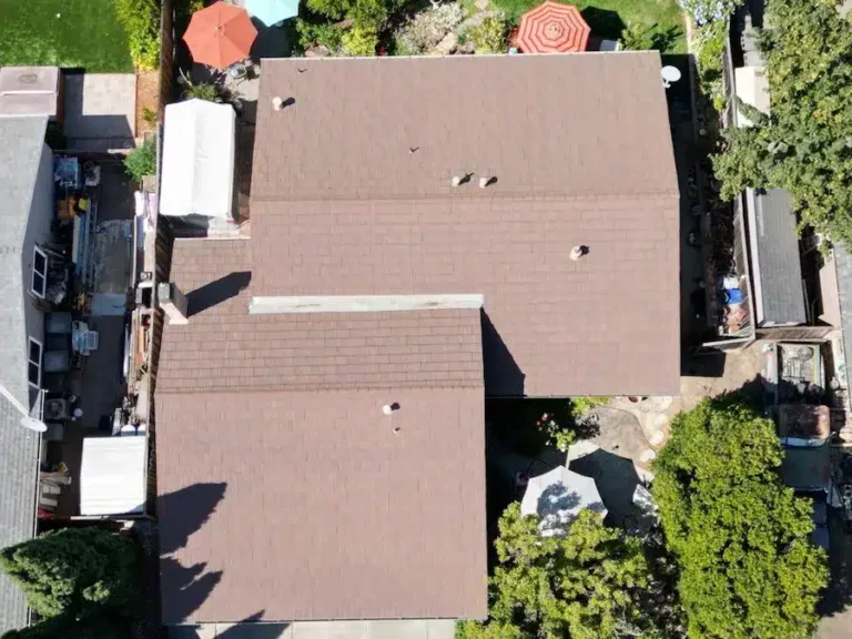Aerial view of worn brown shingle roof before replacement