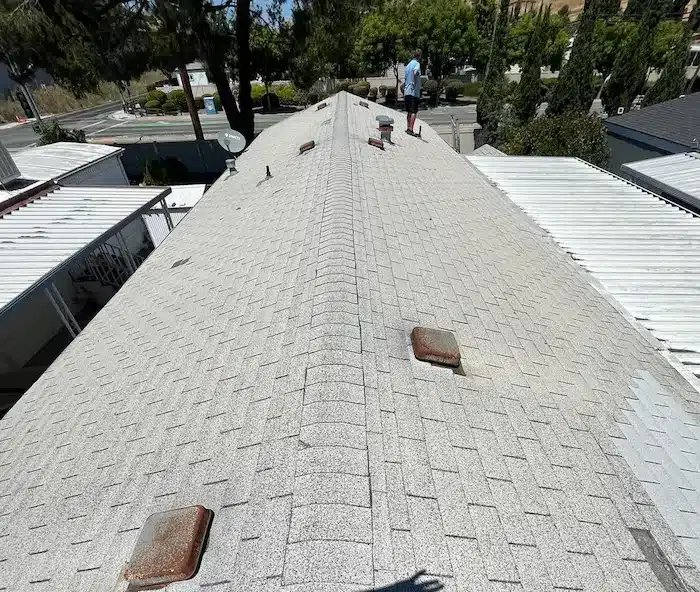 Before image of an aged grey asphalt shingle roof in San Jose showing sun damage and rusted roof vents prior to replacement by Lifetime Roofing.