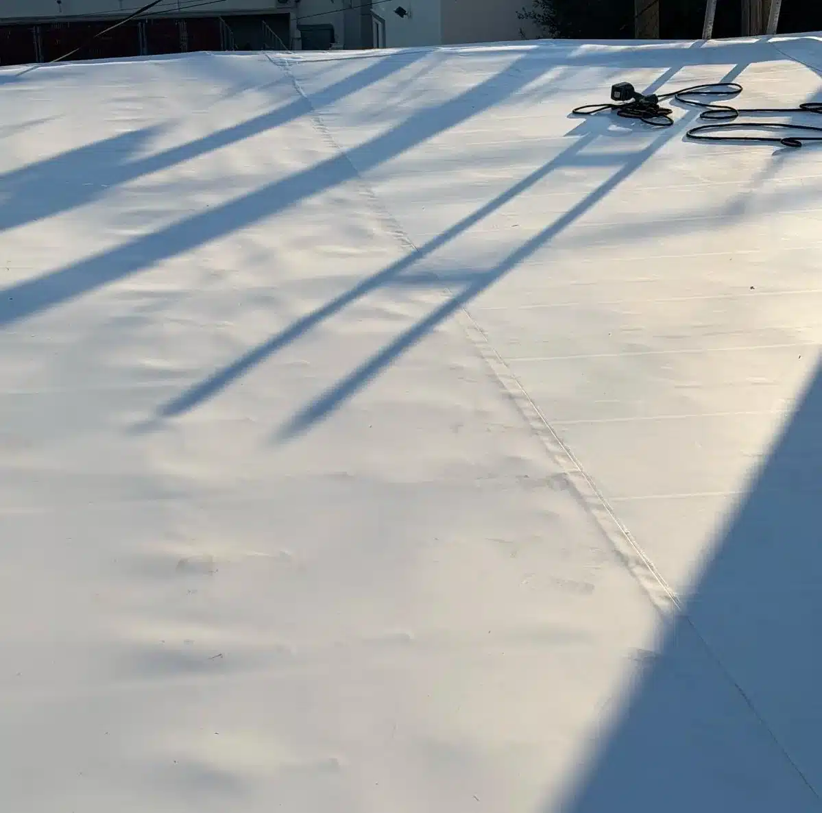 Completed white TPO roof overlay with welded seams and new vent details at 1582 Quesada Ave San Francisco