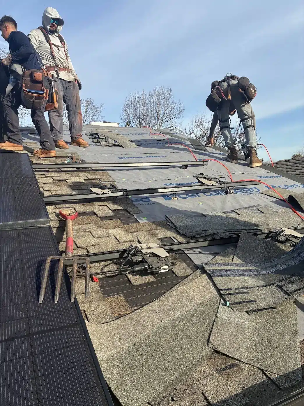 Crew installing CertainTeed DiamondDeck synthetic underlayment around solar rails during a San Jose roof repair