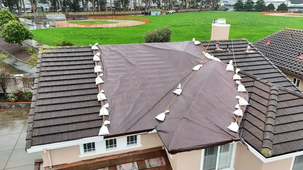 Concrete tile roof tarped and sandbagged before repair at 555 Hibiscus Drive, South San Francisco