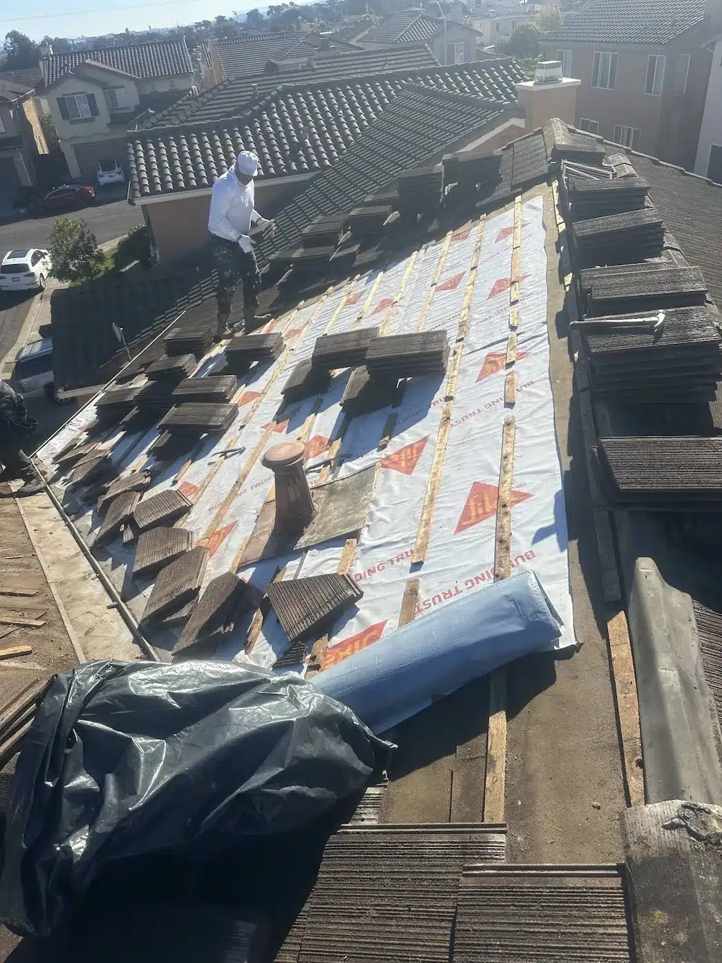 New synthetic underlayment and battens with original concrete tiles stacked for relay at 555 Hibiscus Drive