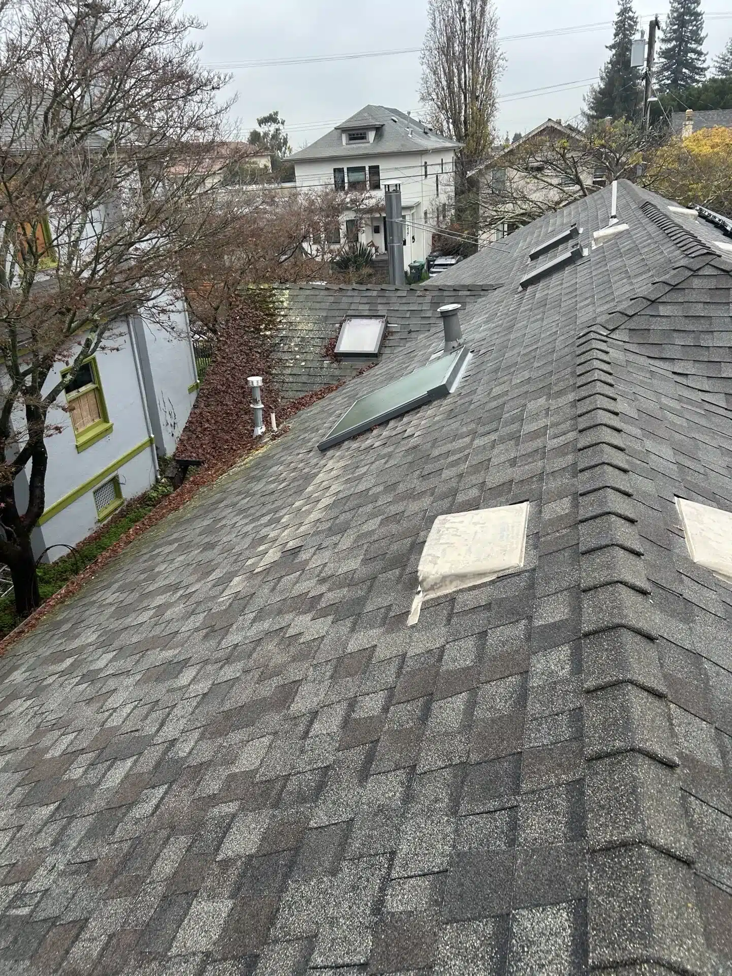Aging shingle roof showing granule loss before replacement at 6430 Colby Street, Oakland CA