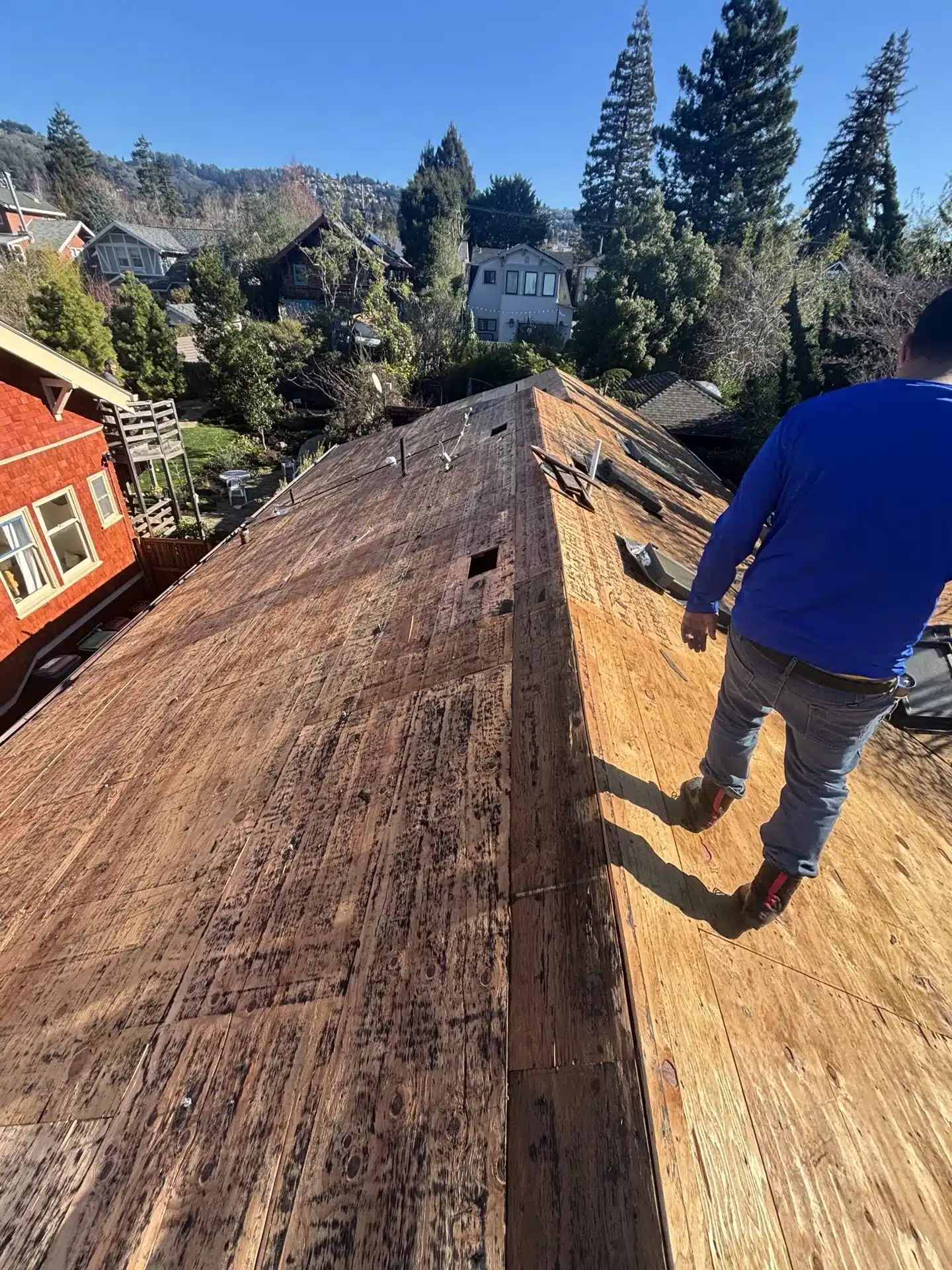 Full roof tear-off exposing the wood deck at 6430 Colby Street, Oakland CA