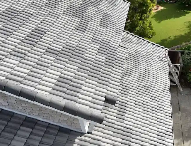 Overhead view of new charcoal-gray concrete tile meeting the home's siding after re-roof in Foster City, CA