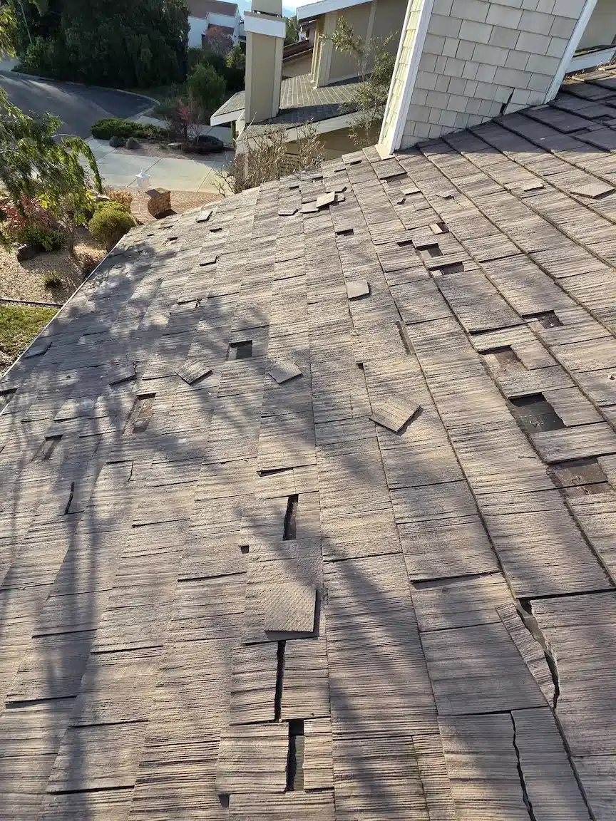 Weathered wood-shake roof with curling and lifting shakes before replacement in Foster City, CA