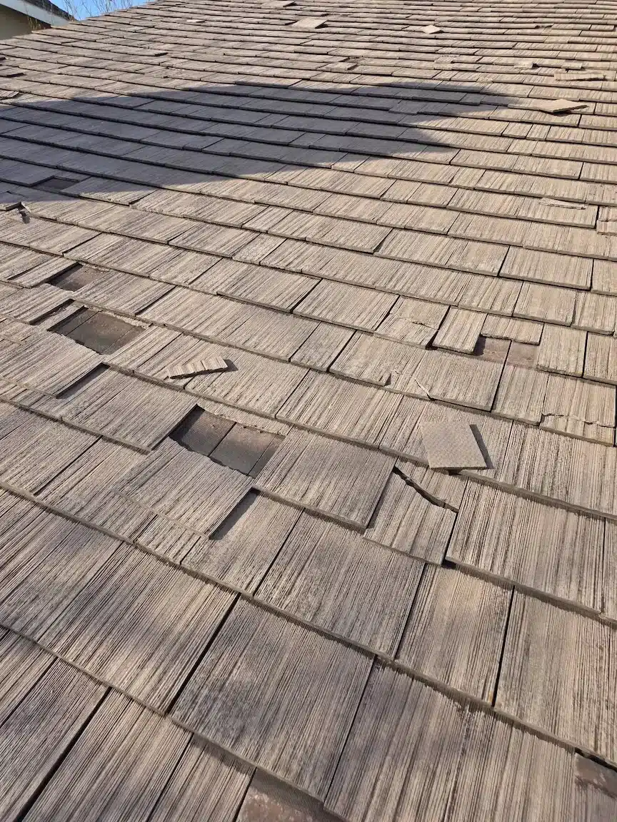 Close-up of split and cracked wood shakes with open gaps before re-roof in Foster City, CA