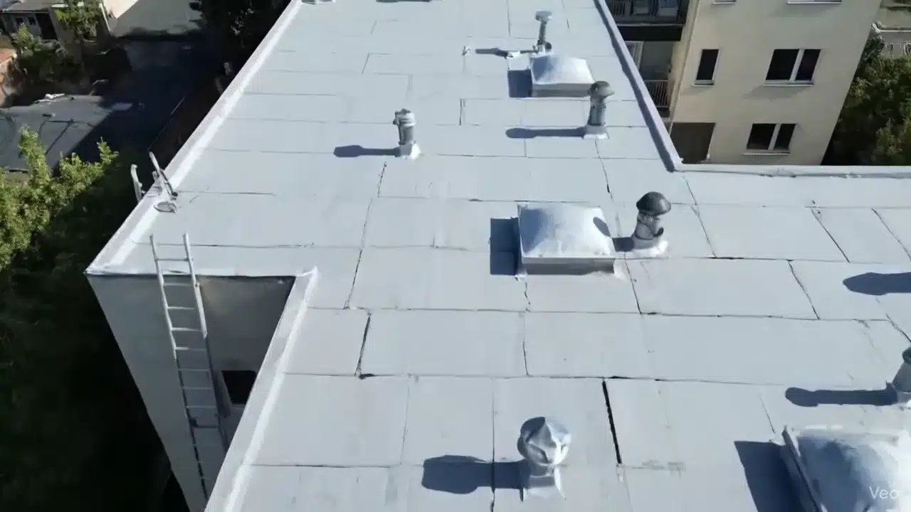 Aerial view of a completed light-gray membrane re-roof on a multi-unit San Francisco building