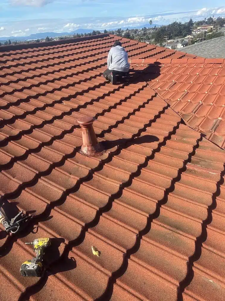 Crew member completing final checks on the relaid tile roof after leak repair in Richmond, CA