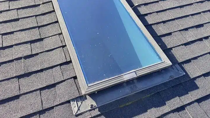 Nine-year-old skylight before replacement with moss along the low edge and lifted apron flashing, Sunnyvale CA