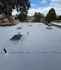 New light-colored modified bitumen flat roof with skylights after a low-slope roof replacement on Chickadee Court in Sunnyvale, CA
