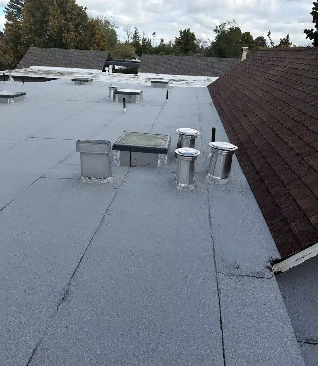 New metal vent caps and flues sealed into the finished modified bitumen flat roof, Sunnyvale CA