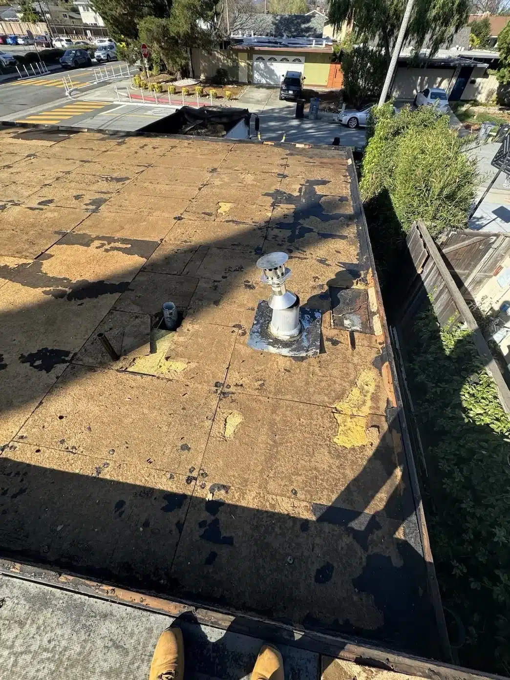 Old low-slope roof stripped back to patched fiberboard before replacement, Sunnyvale CA