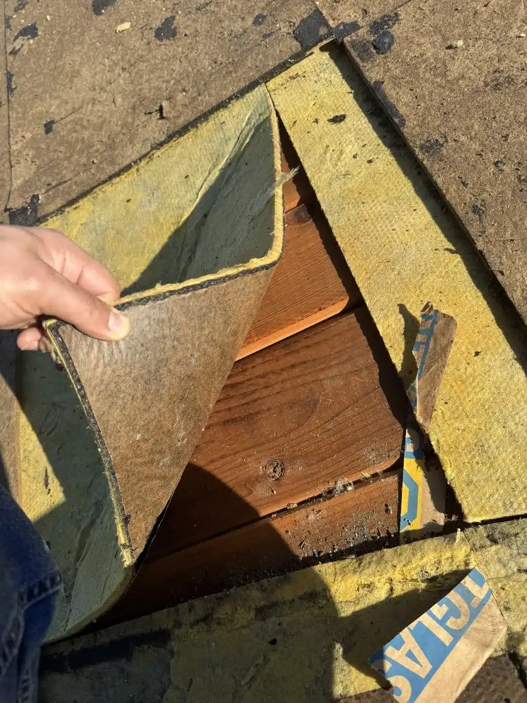 Old built-up roof layers peeled back to reveal fiberglass insulation board over 1x board decking, Sunnyvale CA