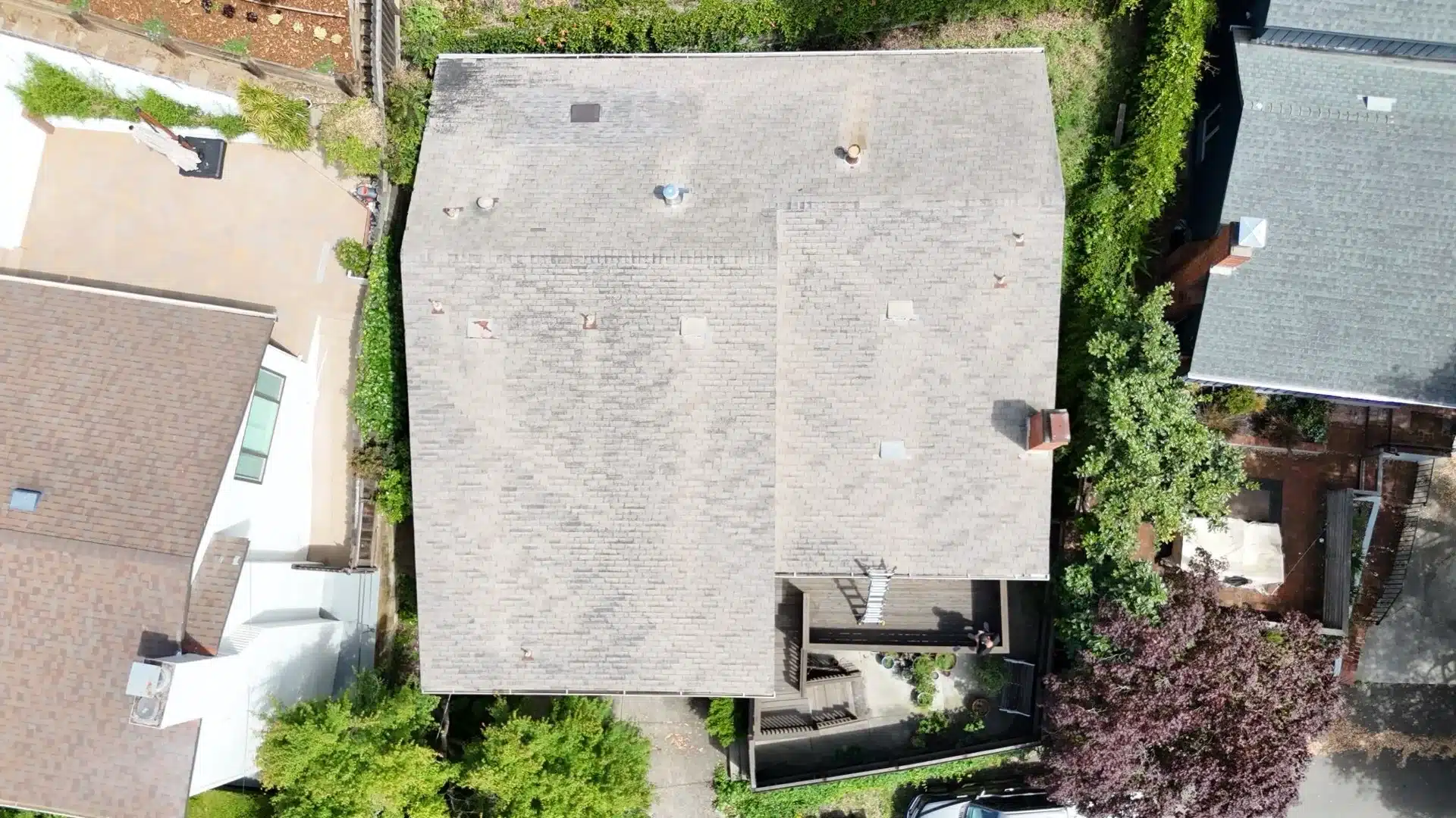 Aerial view of a faded, weathered asphalt shingle roof before replacement in the Oakland Hills