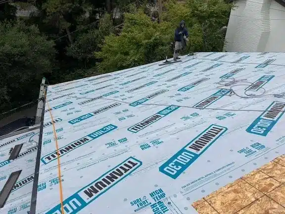 Titanium UDL30 synthetic underlayment installed across the bare roof deck after full tear-off