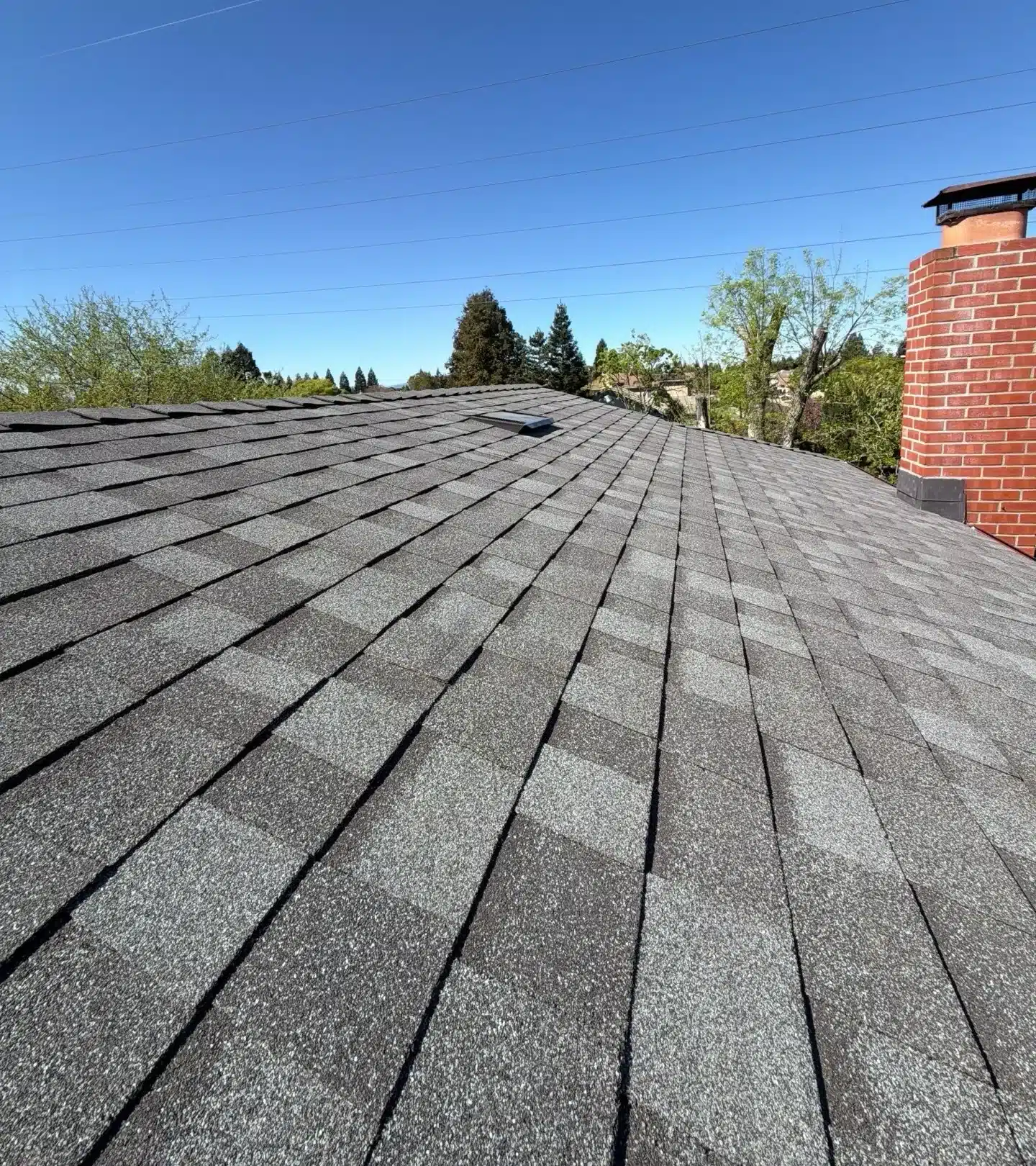 Finished cool-roof shingles running up to the rebuilt chimney flashing in Livermore, CA 94550