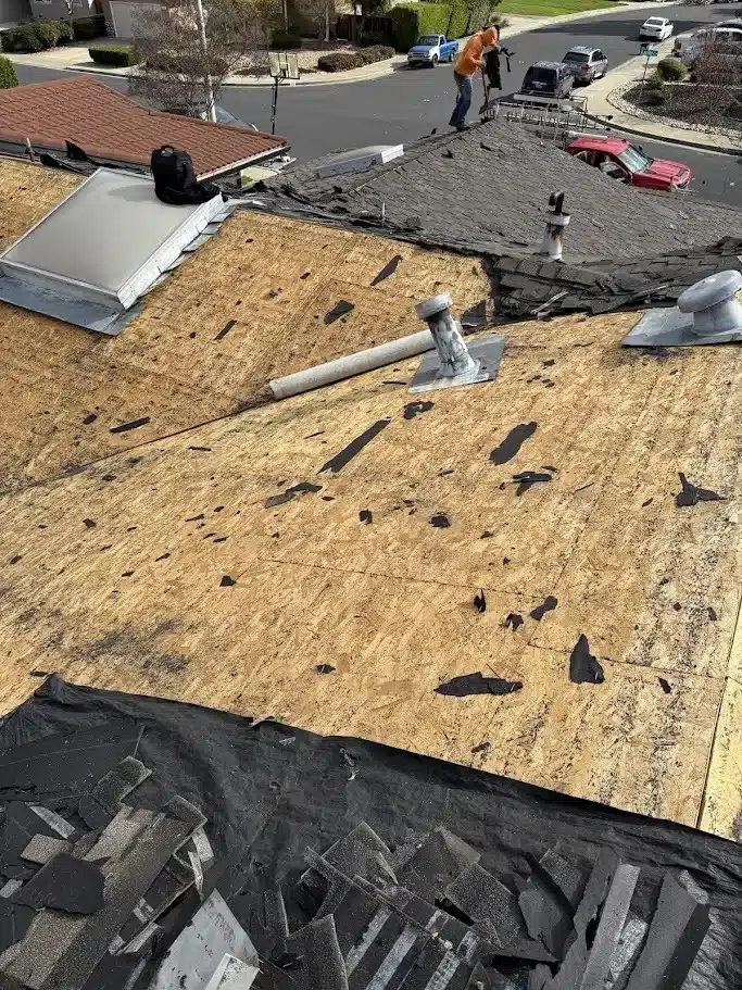 Tear-off in progress with old shingles stripped down to bare decking in Livermore, CA 94550