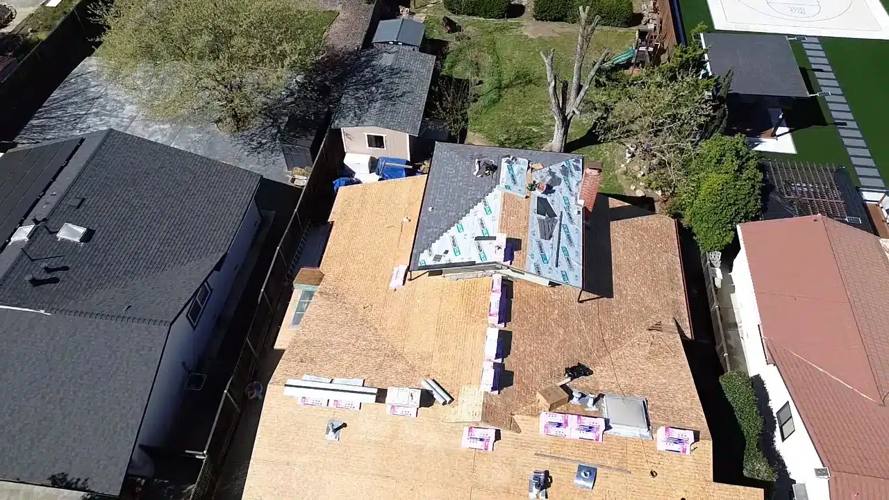 Aerial view of shingle bundles staged across the exposed roof deck mid-replacement in Livermore, CA 94550