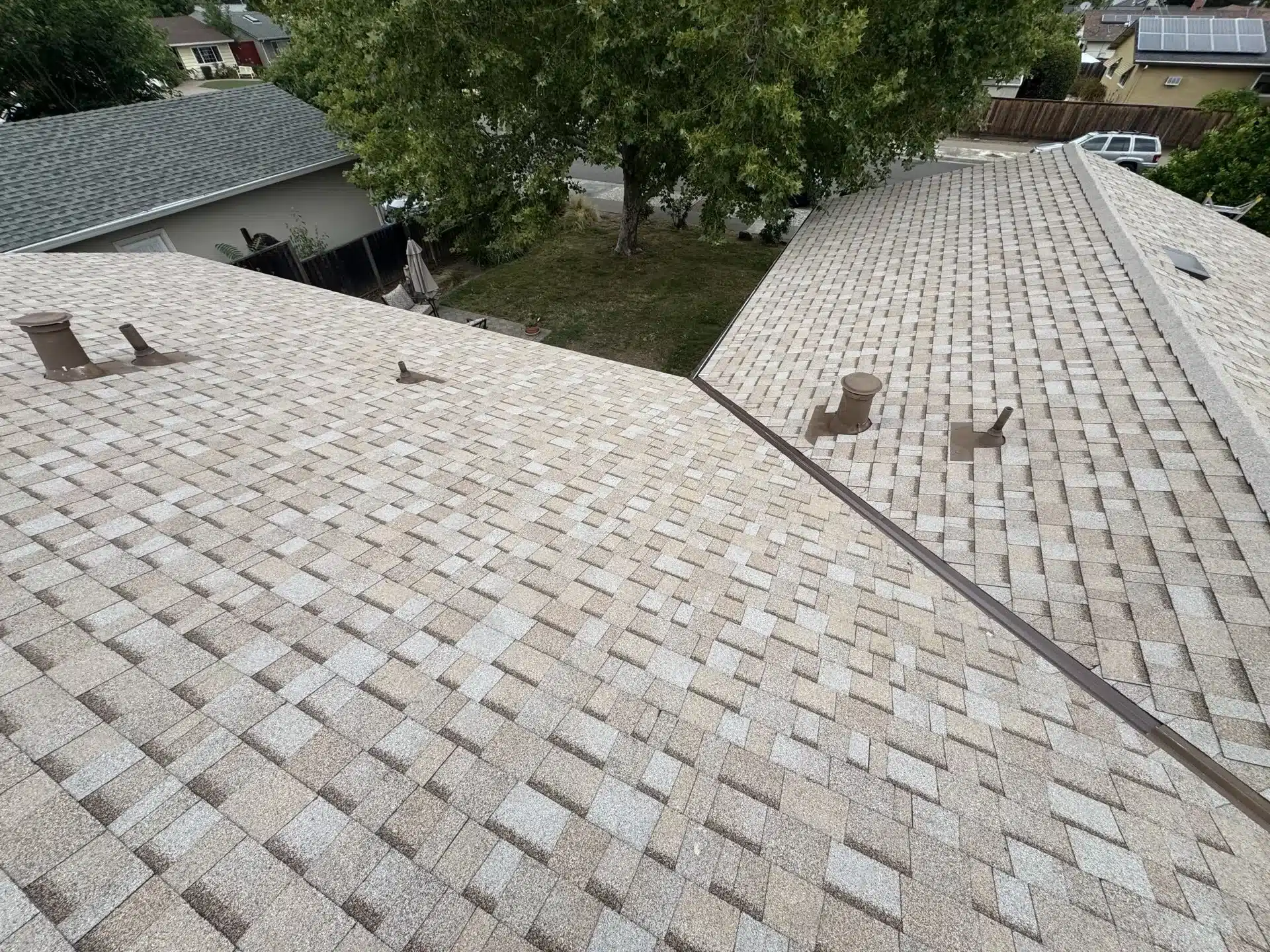 Finished shingle roof with a crisp metal valley and newly installed attic and plumbing vents