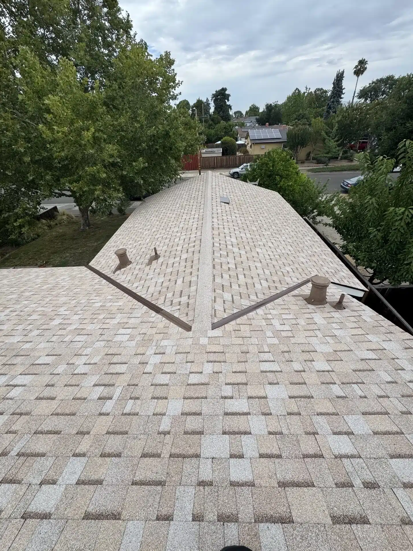 Completed San Jose roof replacement viewed from the ridge toward the street, showing uniform shingle coverage
