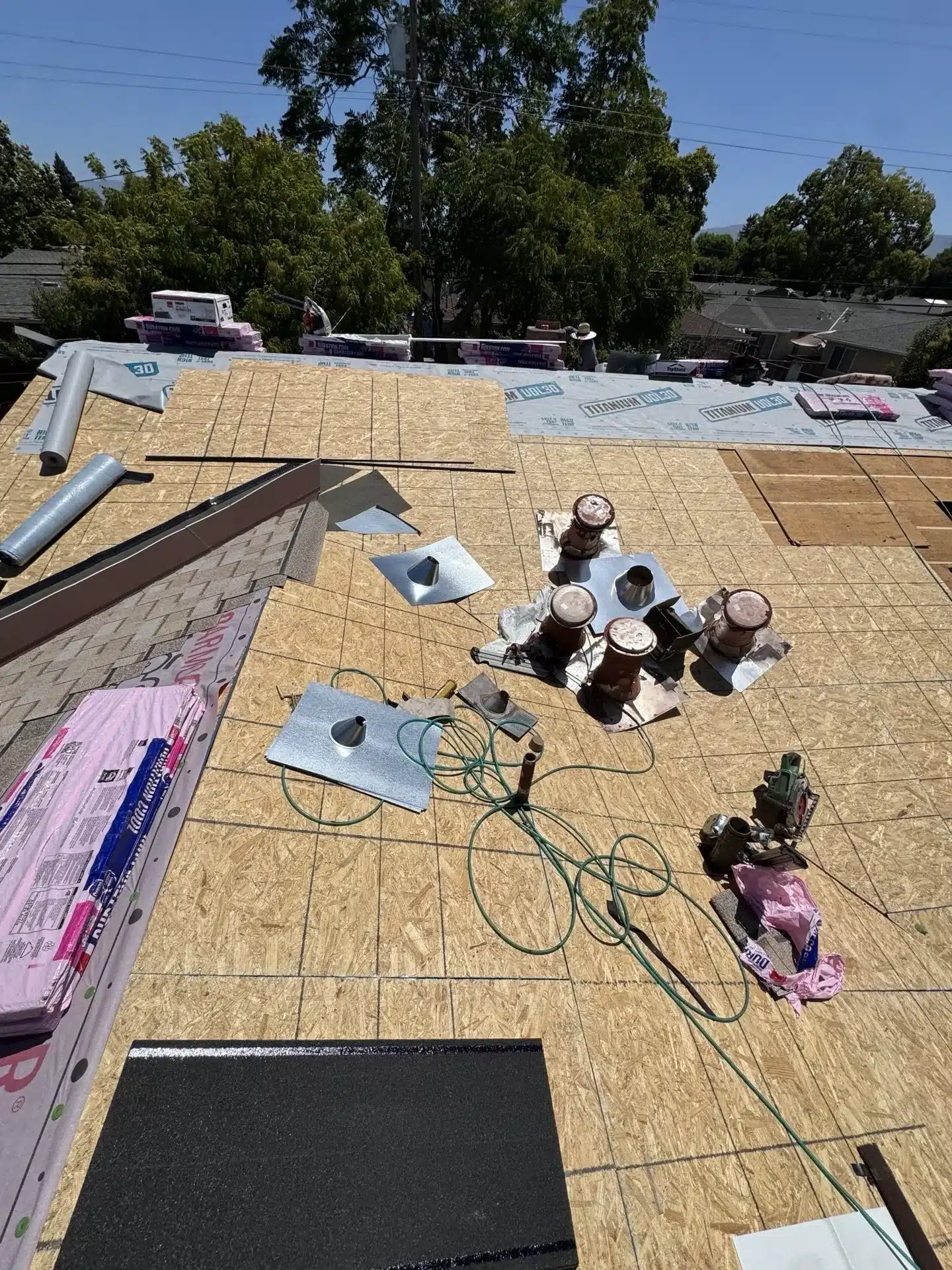 Titanium UDL30 synthetic underlayment over new sheathing with Owens Corning Duration COOL shingle bundles staged for installation