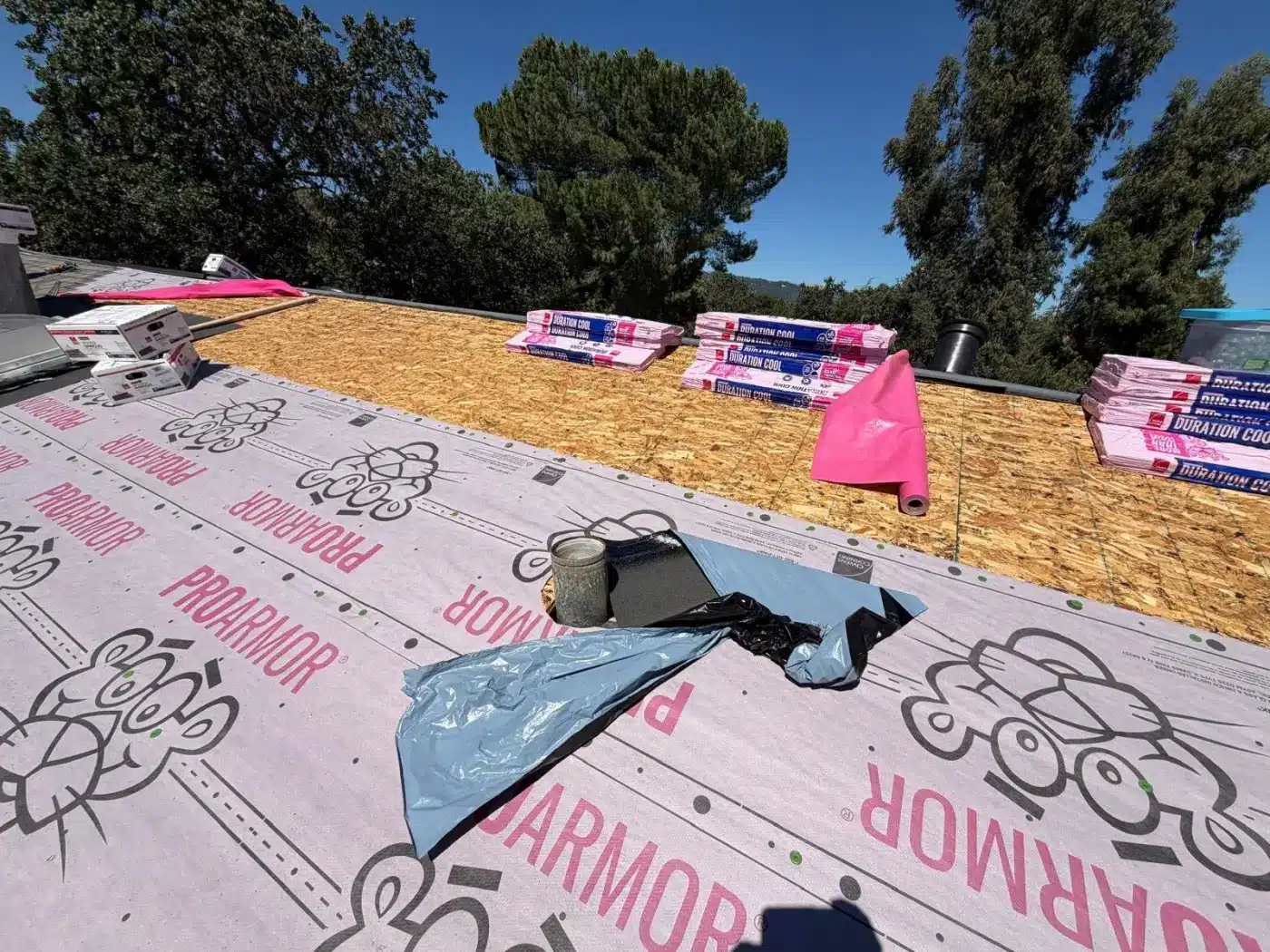 Owens Corning ProArmor synthetic underlayment and Duration COOL shingle bundles staged on the Pleasanton roof deck