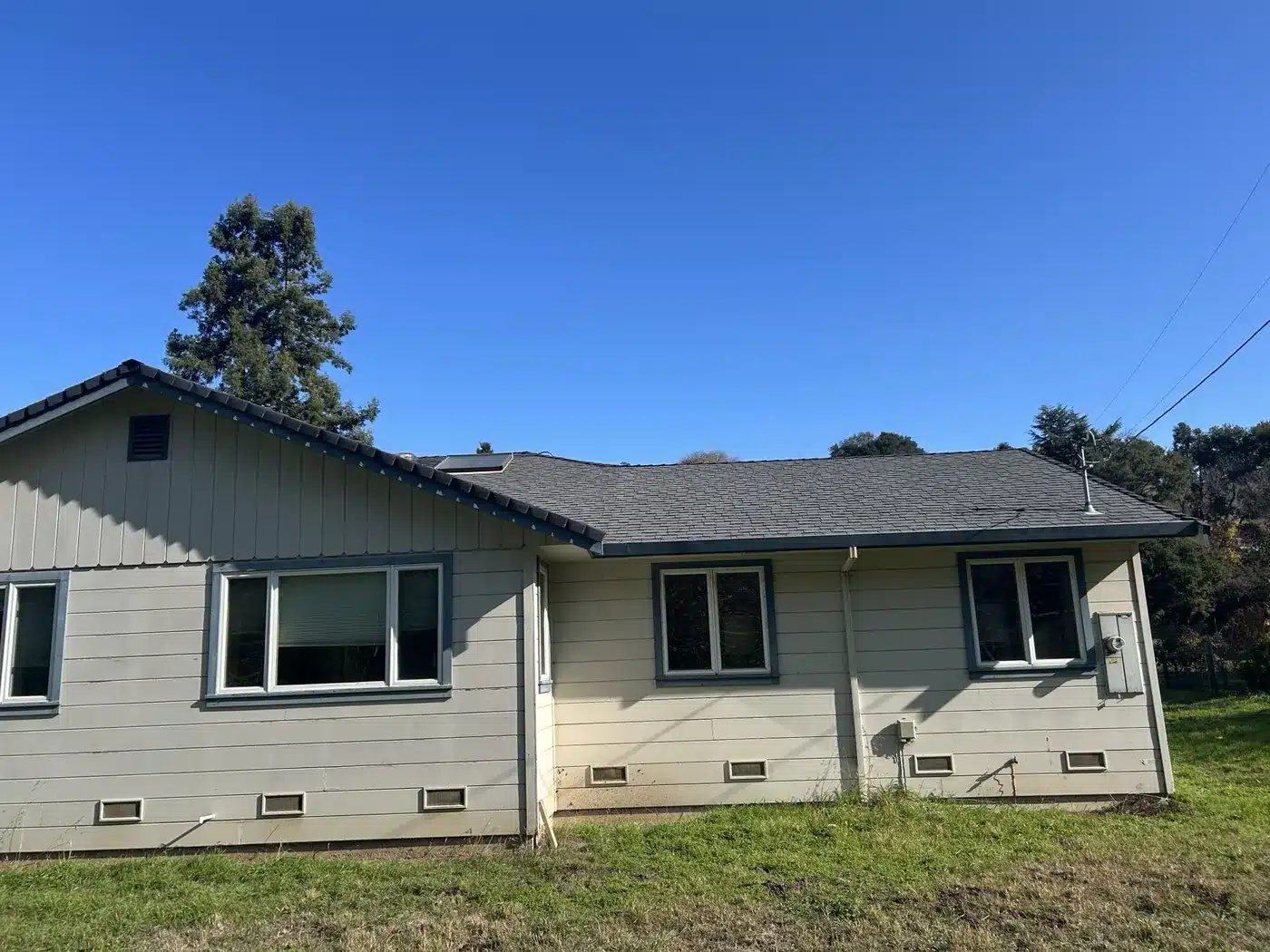 Castro Valley ranch home after the roof replacement with new gray shingles and white gutters