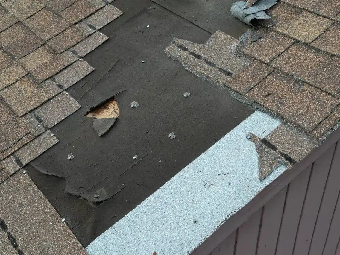 Damaged shingles with exposed patches before re-roofing on Hester Avenue in San Francisco