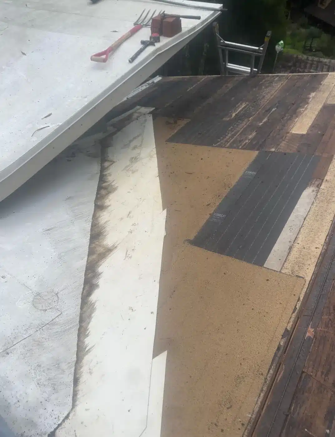 Low-slope roof section stripped of old torch-down before rebuilding in Felton, CA