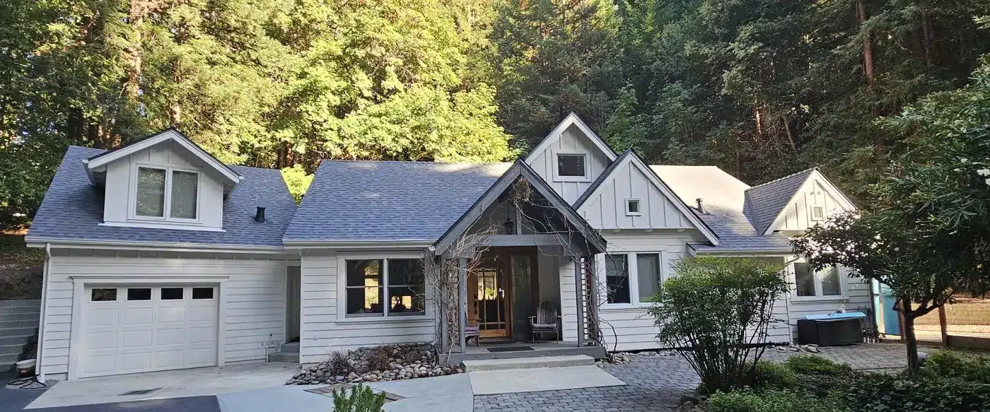 Mountain home in Felton, CA with its aging shingle roof before replacement, redwoods behind