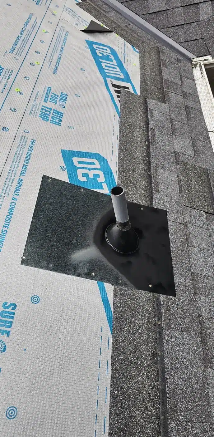 New pipe flashing set into shingles and synthetic underlayment on a Felton roof