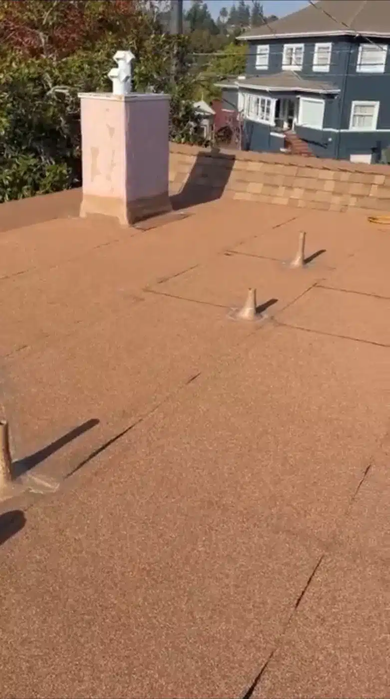 Finished granulated cap-sheet flat roof section with new vents and chimney in Piedmont, CA