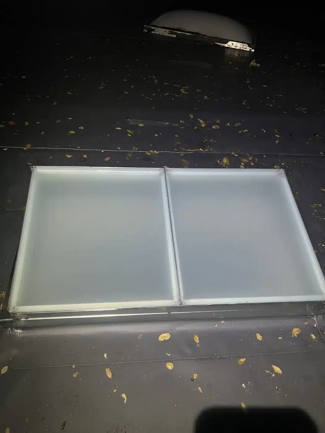 New skylight curb flashed into dark gray TPO membrane on a finished Los Gatos flat roof