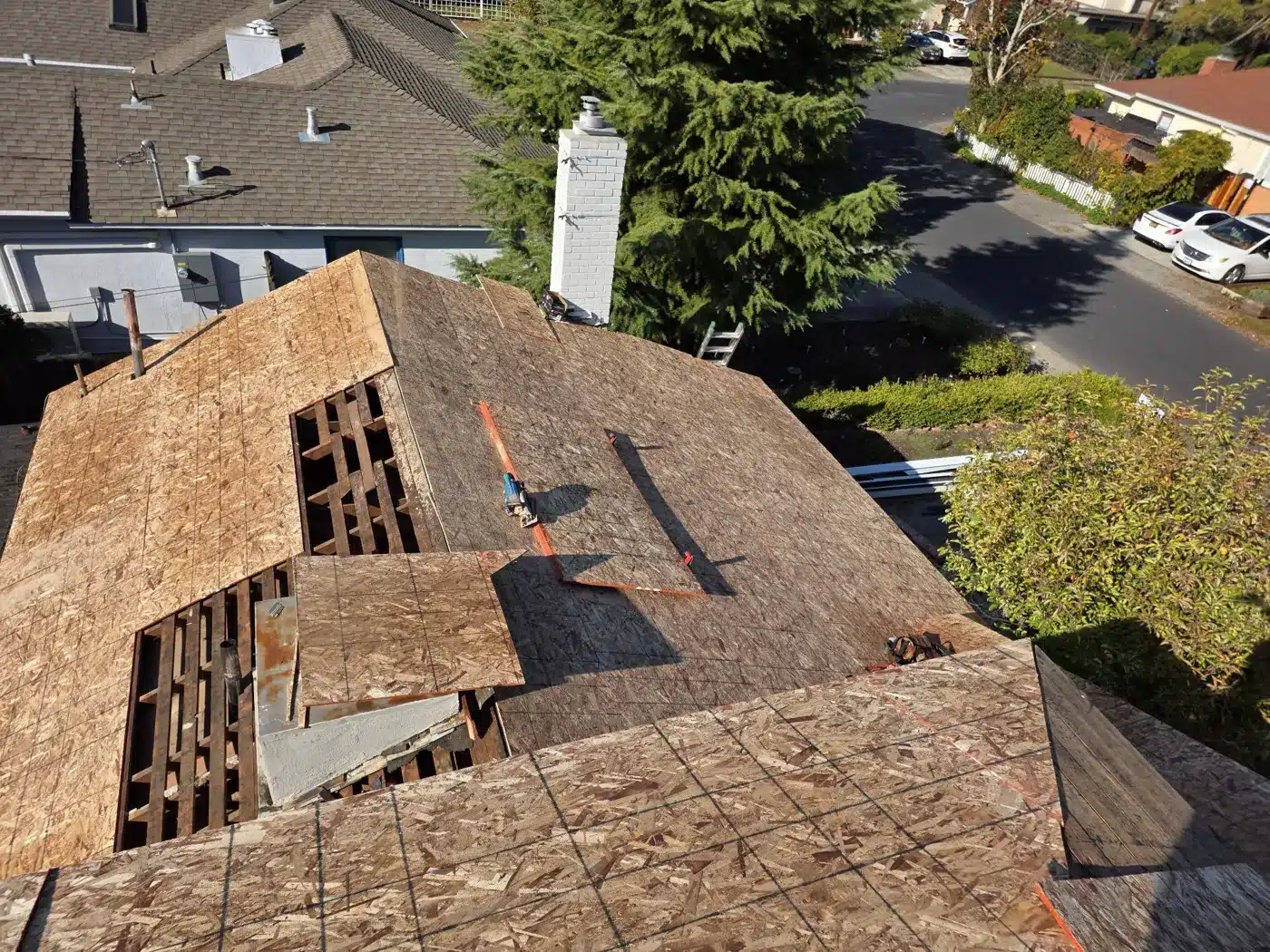 New plywood deck being installed over skip sheathing during a shake-to-shingle conversion in Palo Alto, CA