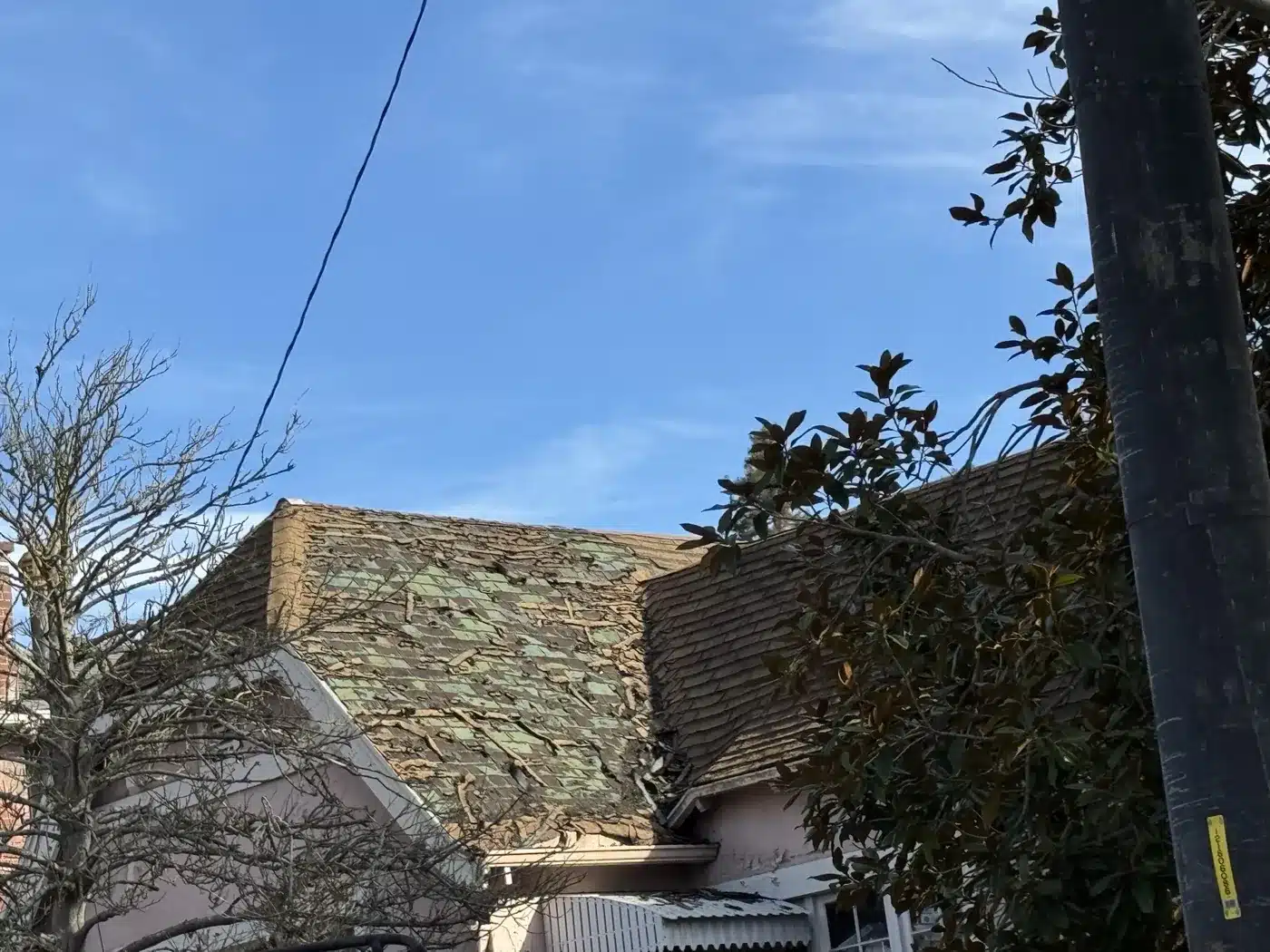 Moss-covered aging roof on a stucco Piedmont home before replacement