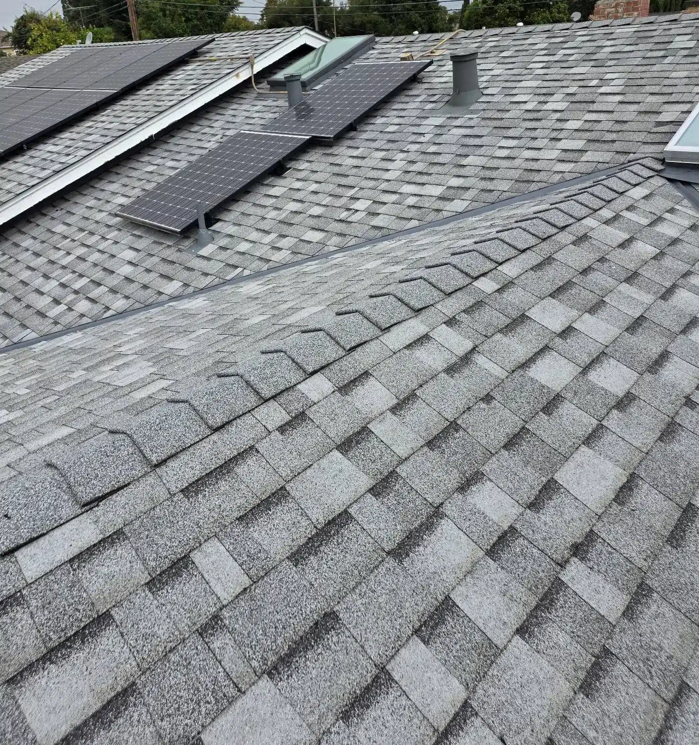 Finished grey architectural shingle roof on a San Jose home with the solar panels reinstalled after the reroof