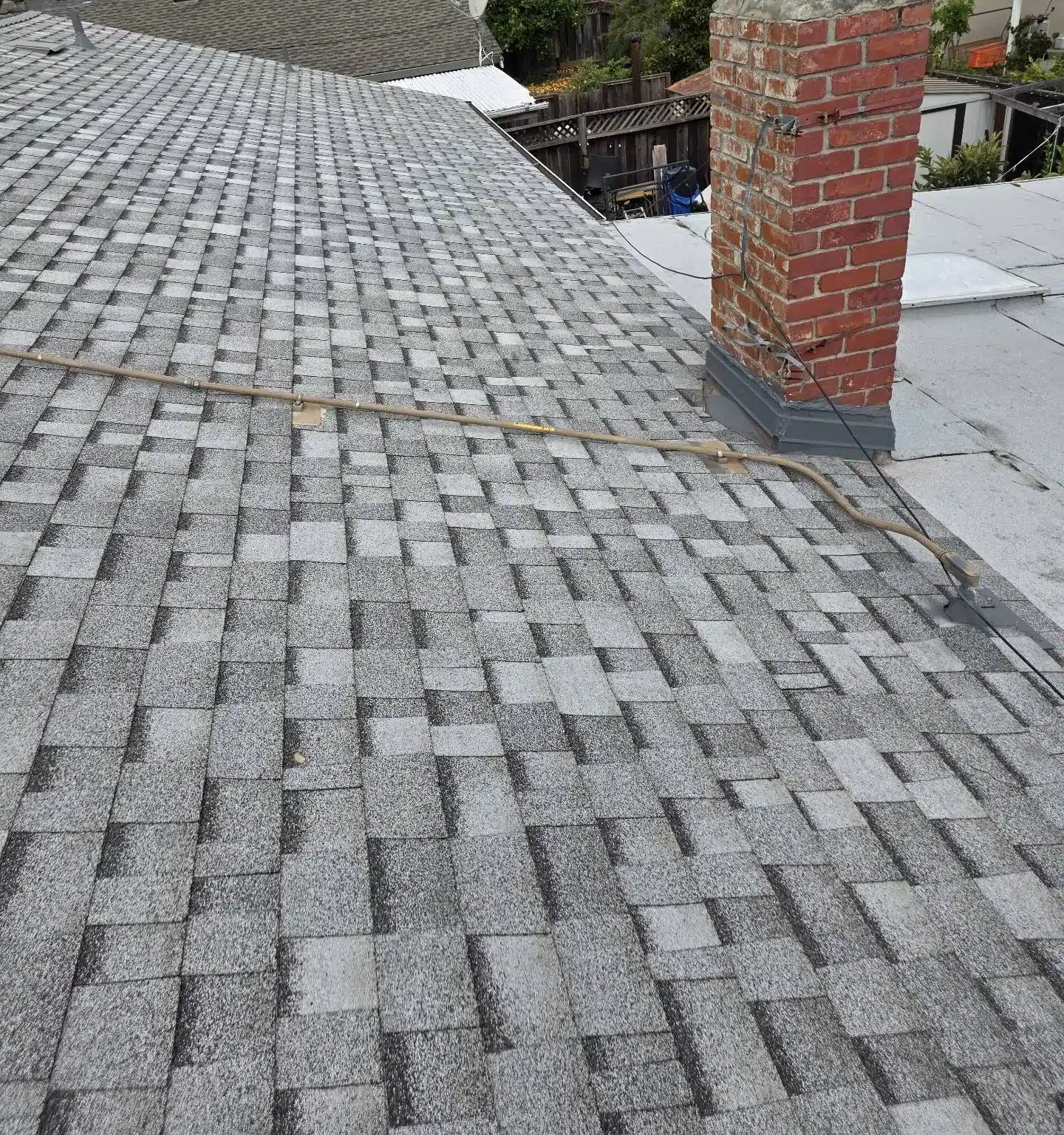 Finished architectural shingle field and chimney on a completed San Jose roof replacement