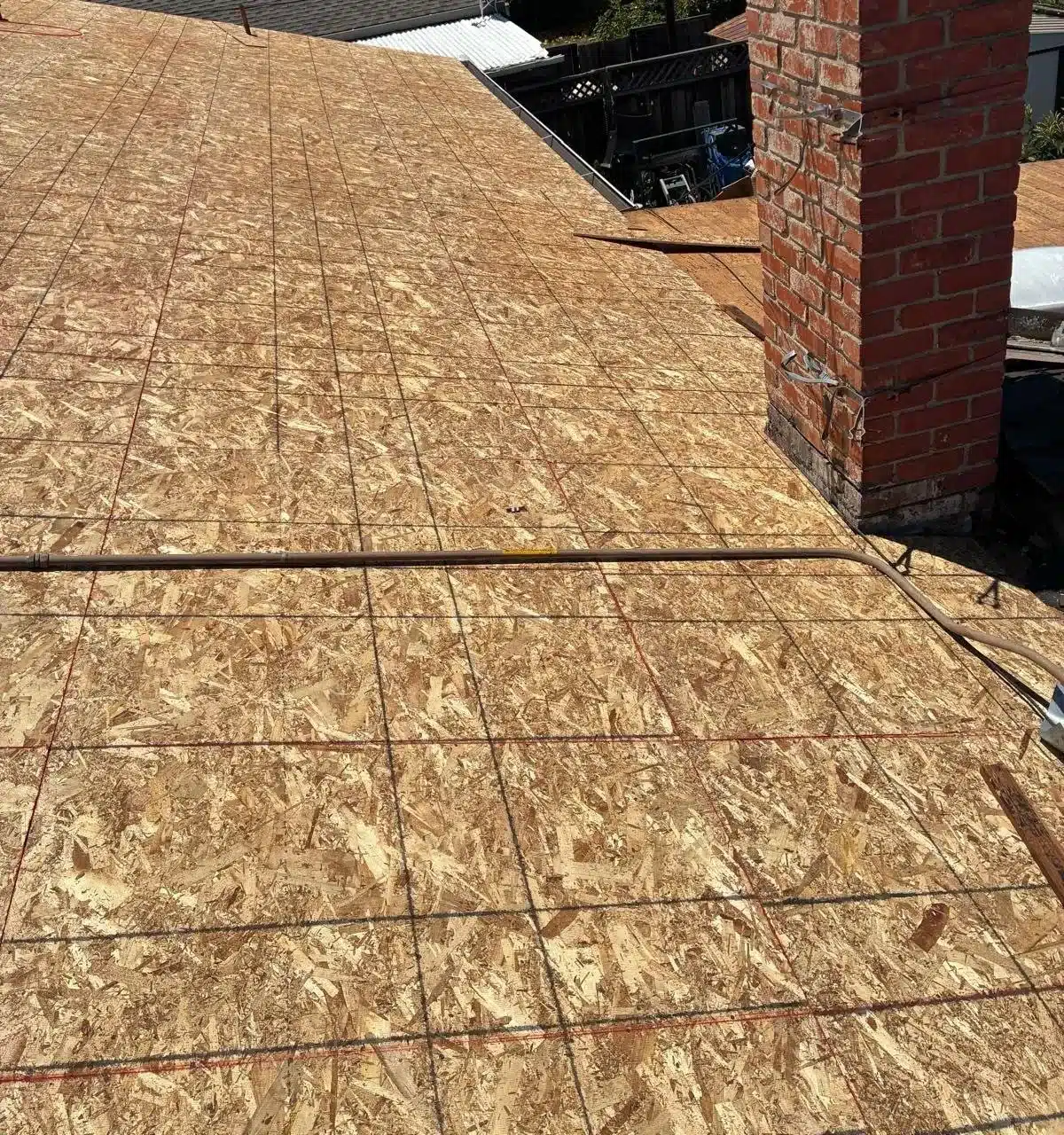 New plywood sheathing installed over the whole plane of a San Jose roof after the spaced planks were covered