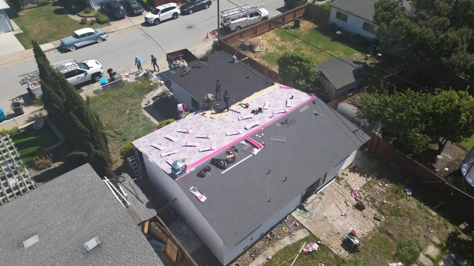 Underlayment rolled out and seam-taped across the roof at Maxine Ave, San Mateo, with the low-slope section beyond