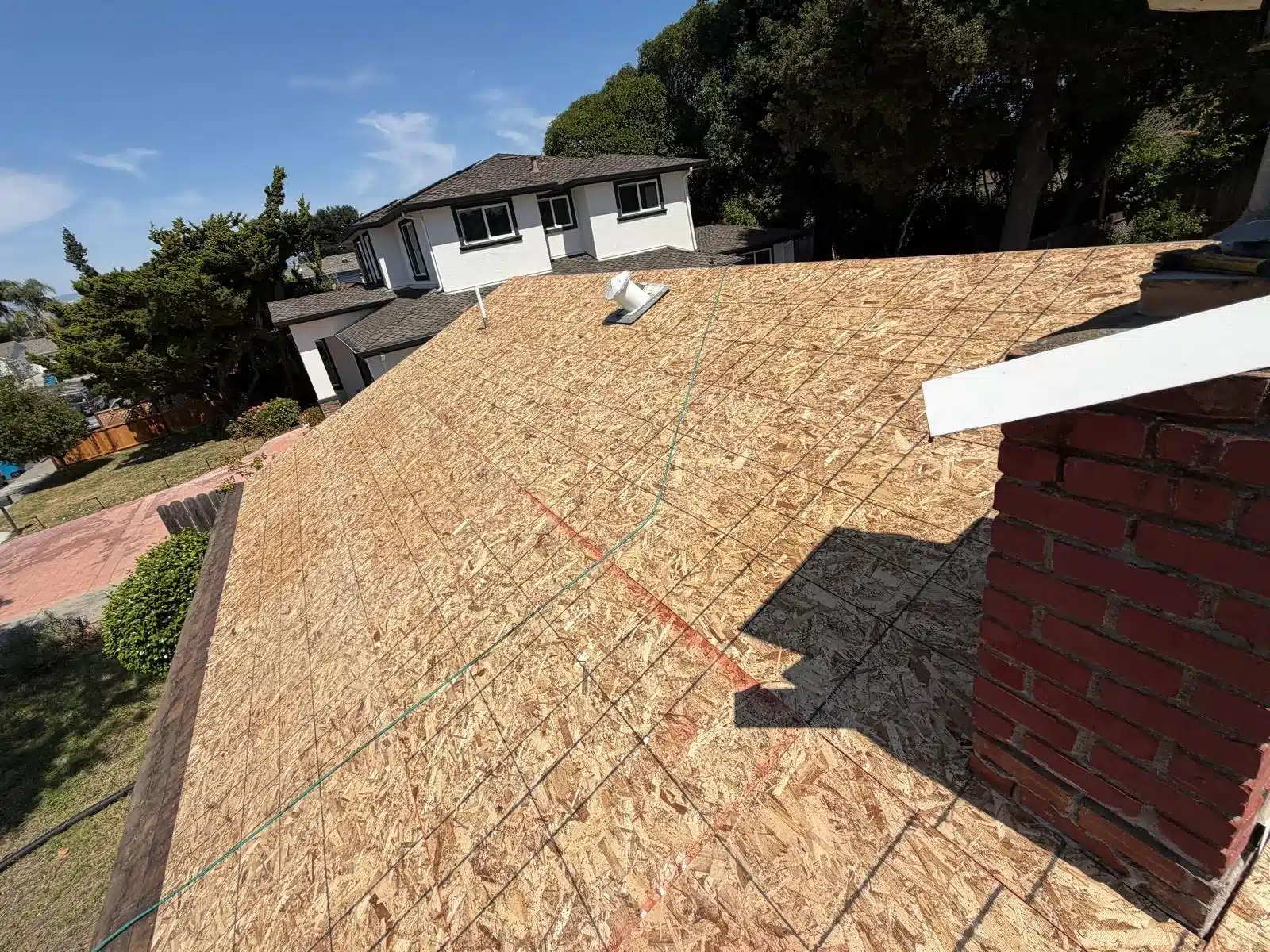 New OSB roof decking fully installed around the brick chimney at 2168 Forbes Avenue, Santa Clara CA