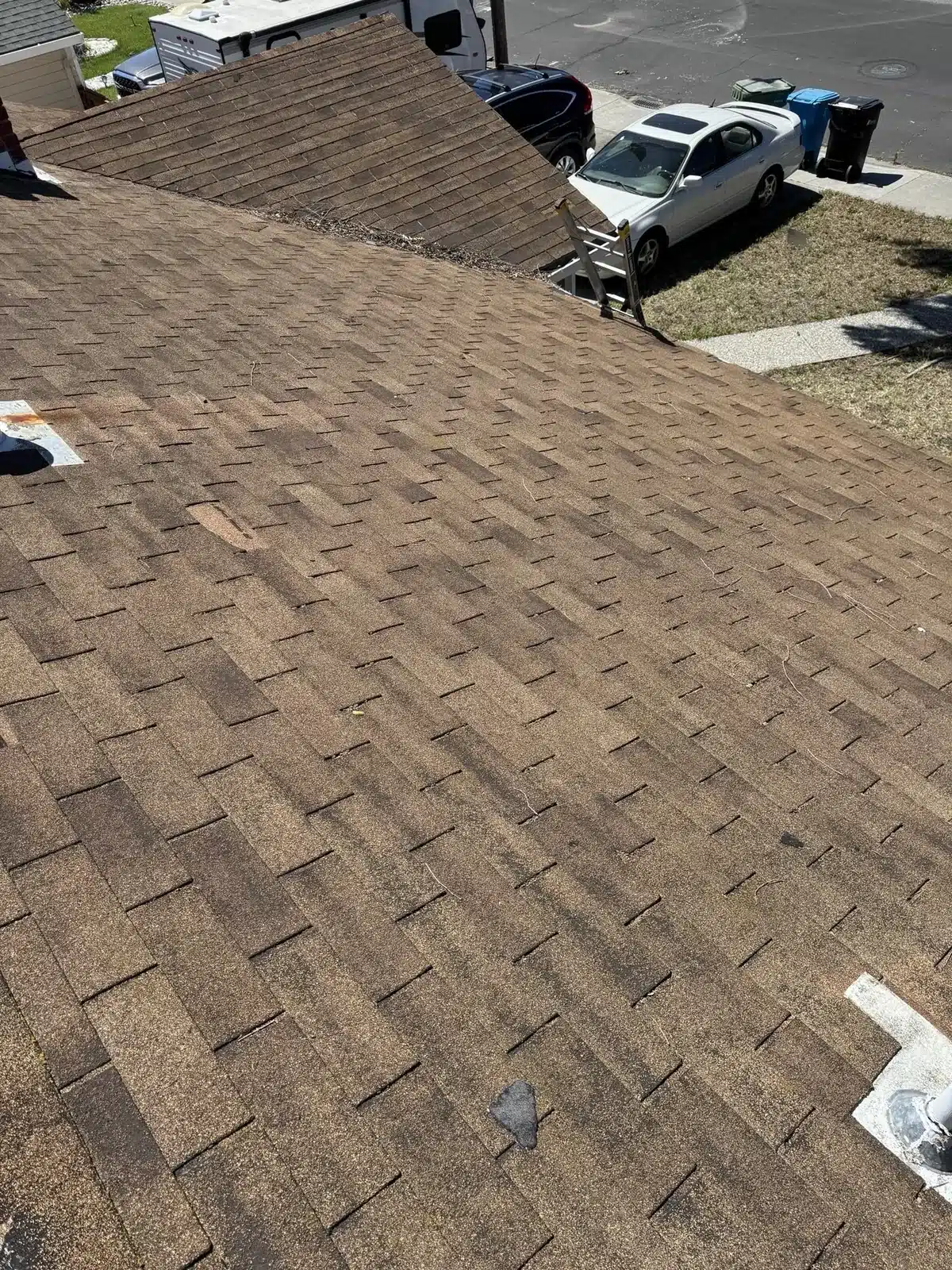 Worn brown three-tab shingle roof seen from above before tear-off at 2168 Forbes Avenue, Santa Clara CA