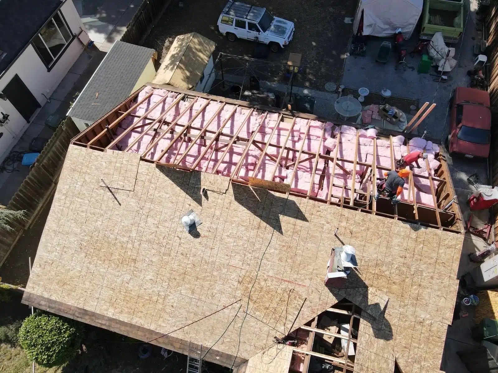 Tear-off complete on one slope with rafters and batt insulation exposed at 2168 Forbes Avenue, Santa Clara CA