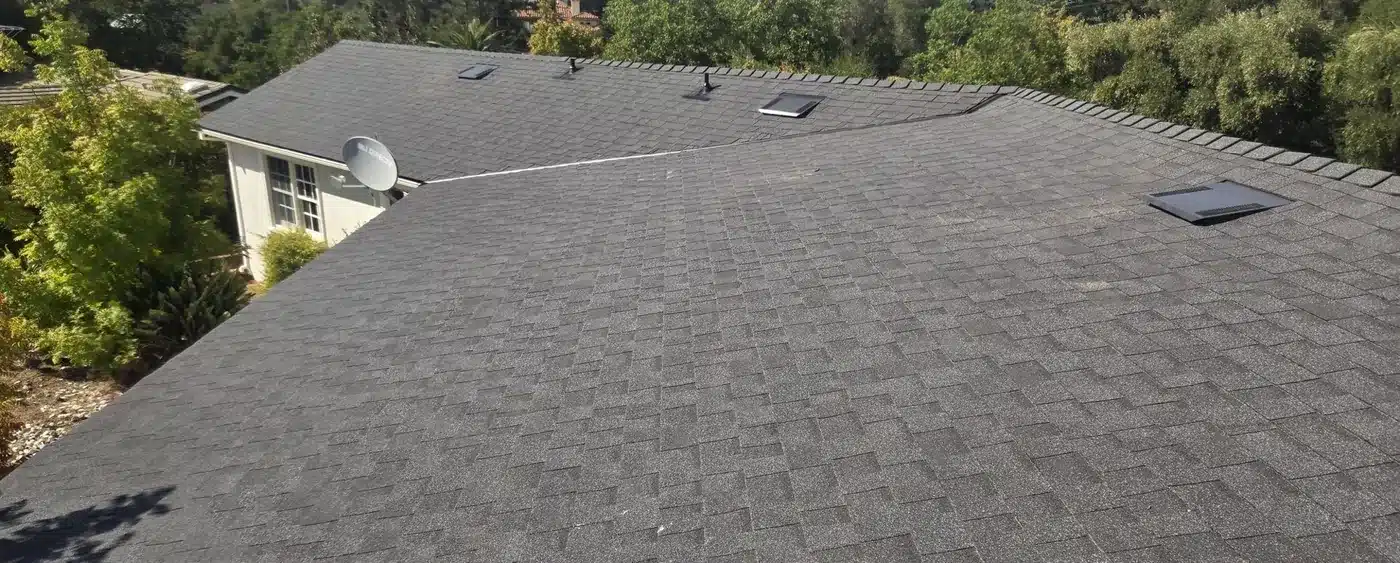 Finished Owens Corning charcoal shingle roof with skylight on a Saratoga hillside home