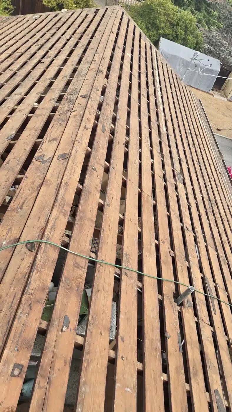 Original skip sheathing exposed after cedar shake tear-off in Saratoga, CA