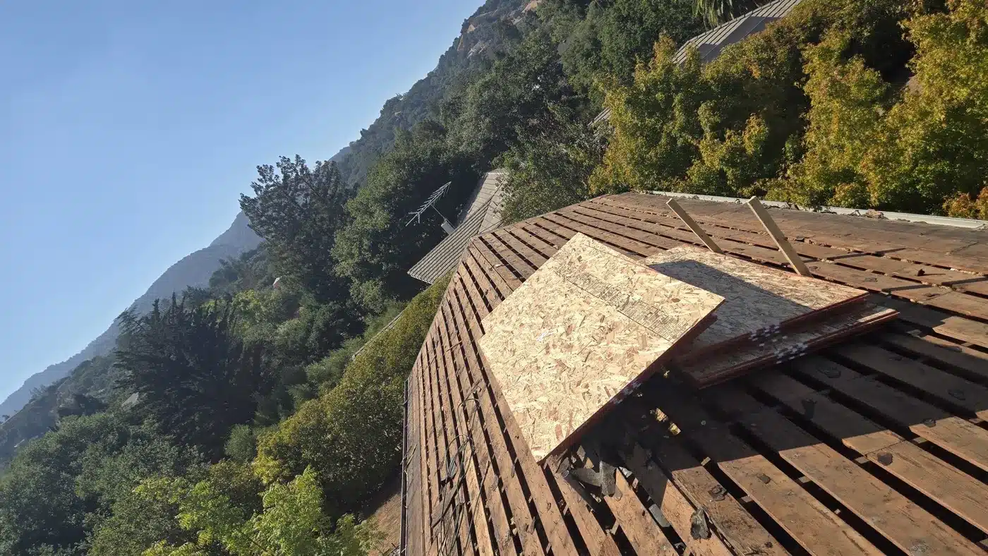 OSB overlay starting over skip sheathing on a Saratoga hillside roof with the Santa Cruz Mountains behind