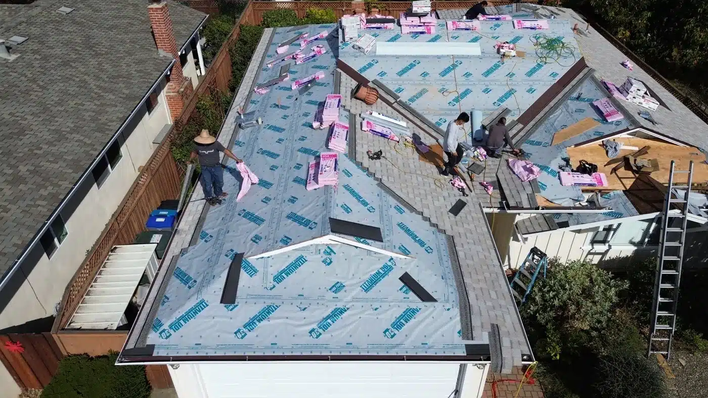 Crew installing shingles over synthetic underlayment during a reroof in Mountain View, CA